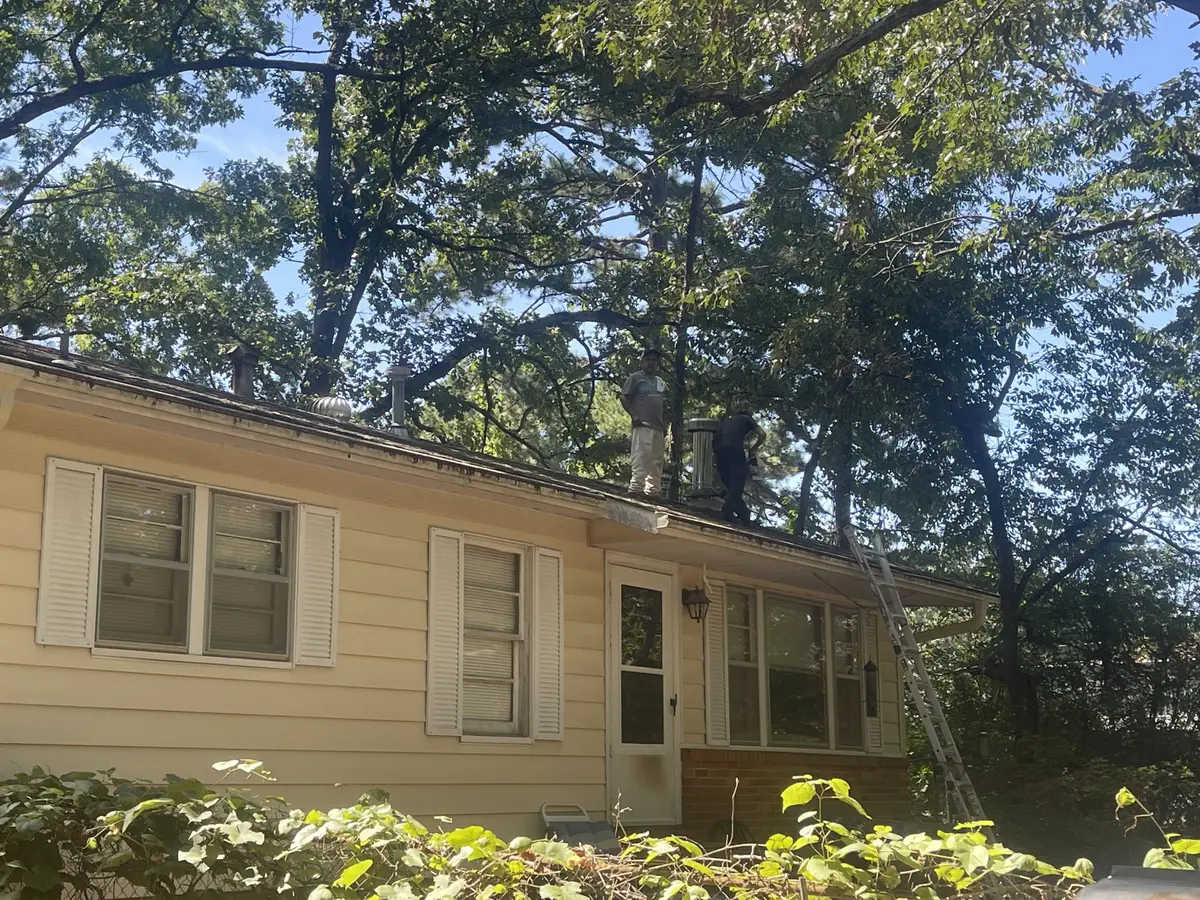 Hero Roofing crew on the roof of a home with light-colored siding in Central Arkansas