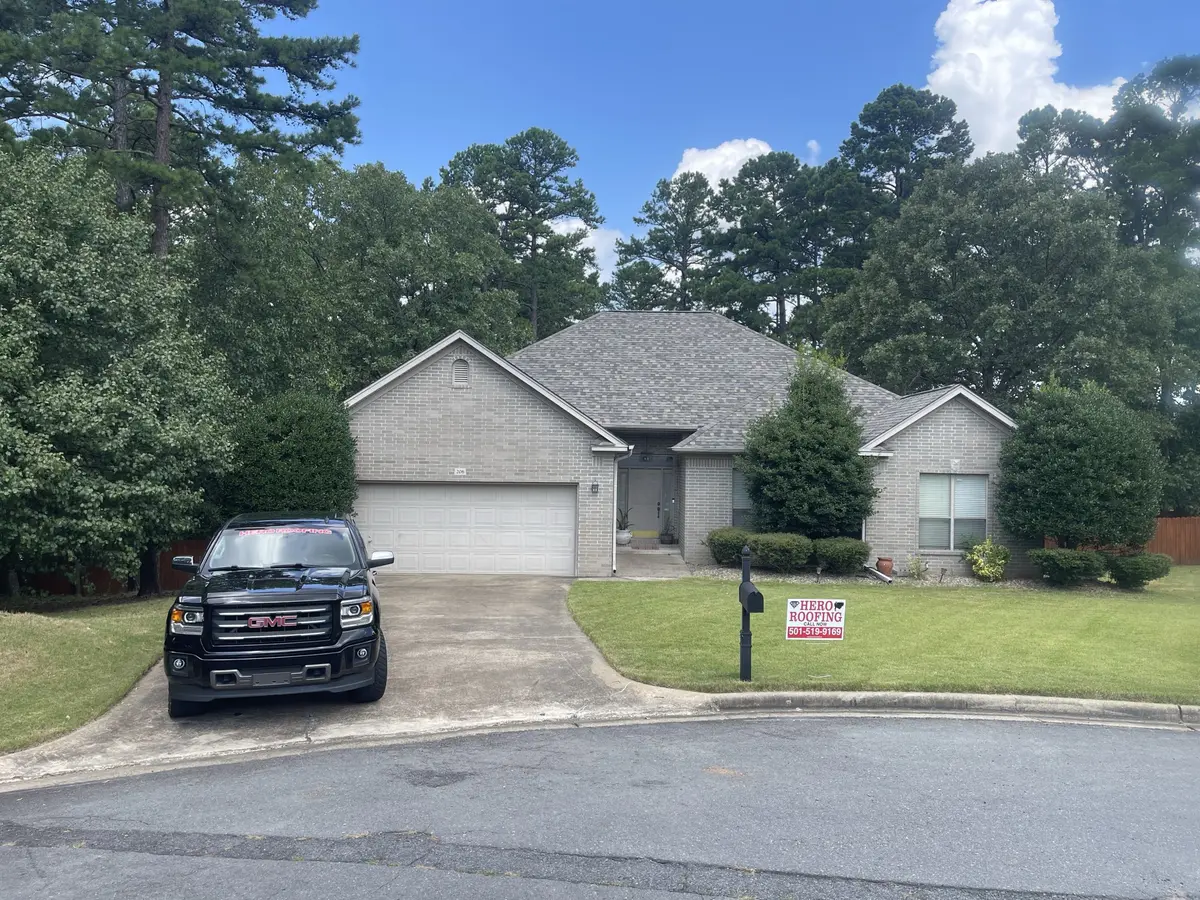 Completed roof replacement on a gray brick home in Central Arkansas with the Hero Roofing truck on site