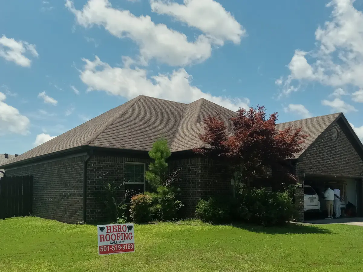 Finished asphalt shingle hip roof on a brick home in Central Arkansas with a Hero Roofing yard sign