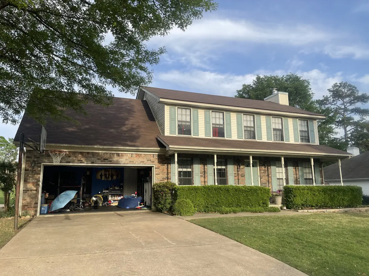 Completed asphalt shingle roof on a two-story home with green shutters in Central Arkansas by Hero Roofing