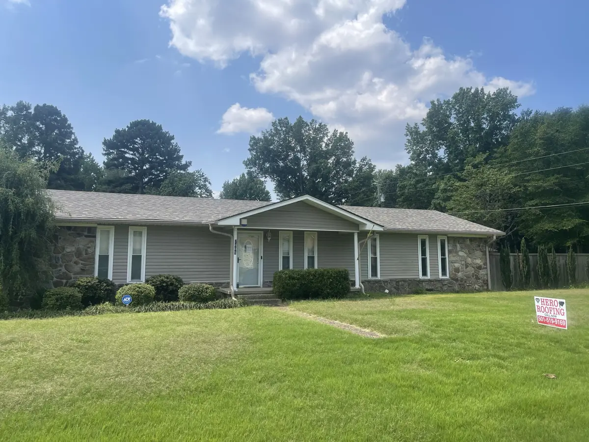 Completed asphalt shingle roof on a stone-and-siding ranch home in Central Arkansas with a Hero Roofing yard sign