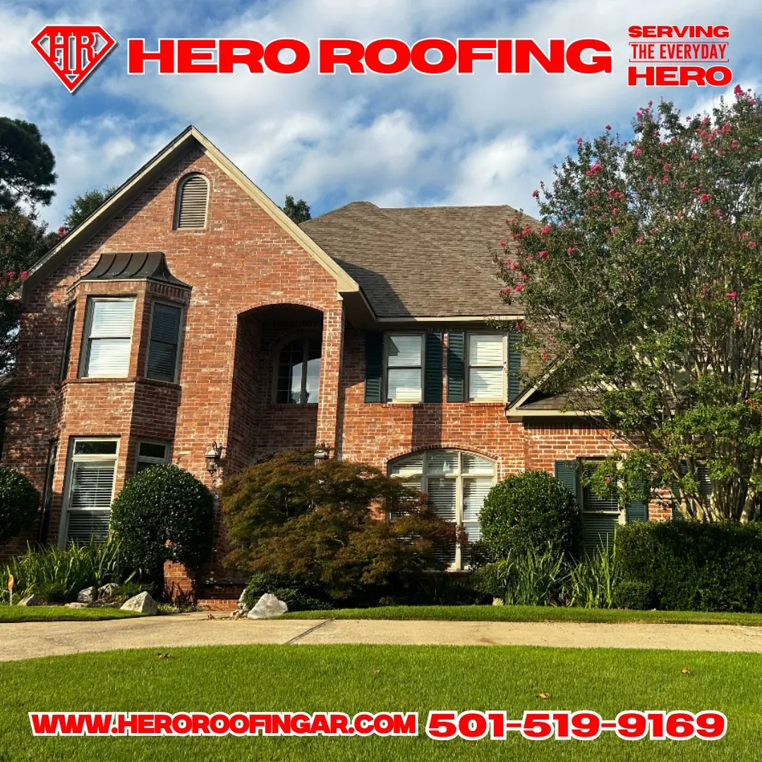 Completed asphalt shingle roof on a large two-story red brick home with green shutters in Central Arkansas by Hero Roofing