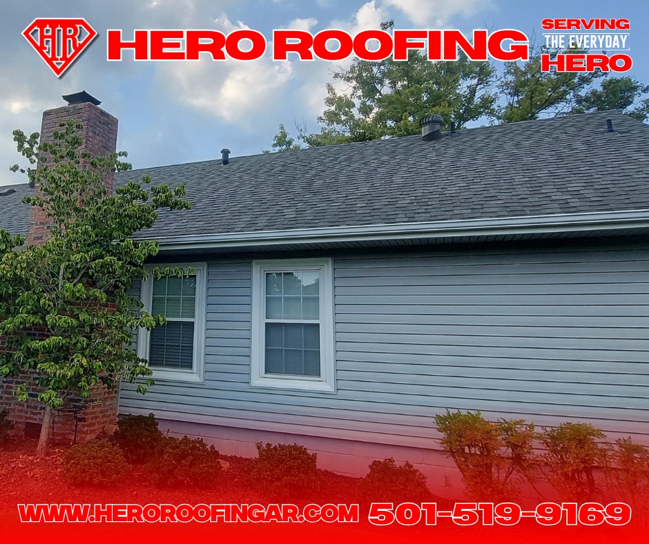 Completed asphalt shingle roof on a home with gray siding and a brick chimney in Central Arkansas by Hero Roofing