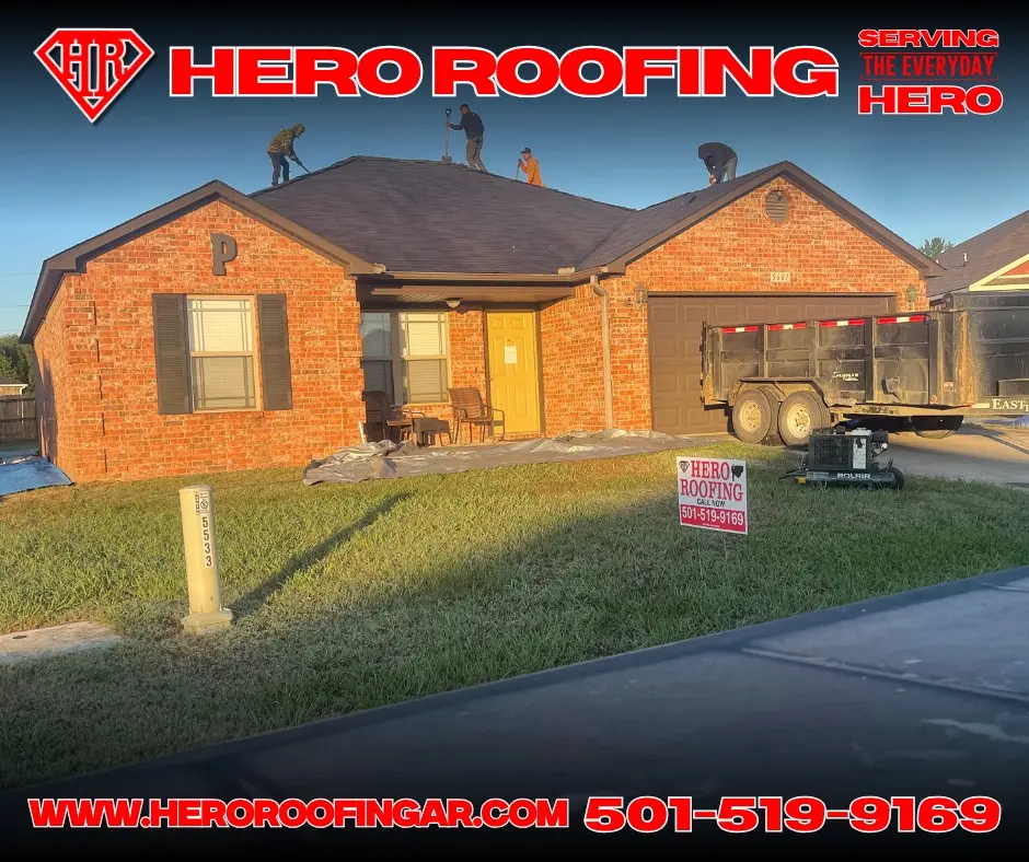Hero Roofing crew replacing the roof on a brick home in Central Arkansas, with a dump trailer and a Hero Roofing yard sign on site